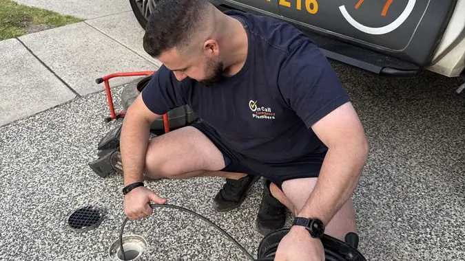 Plumber preparing a drain cleaning hose, Mordialloc